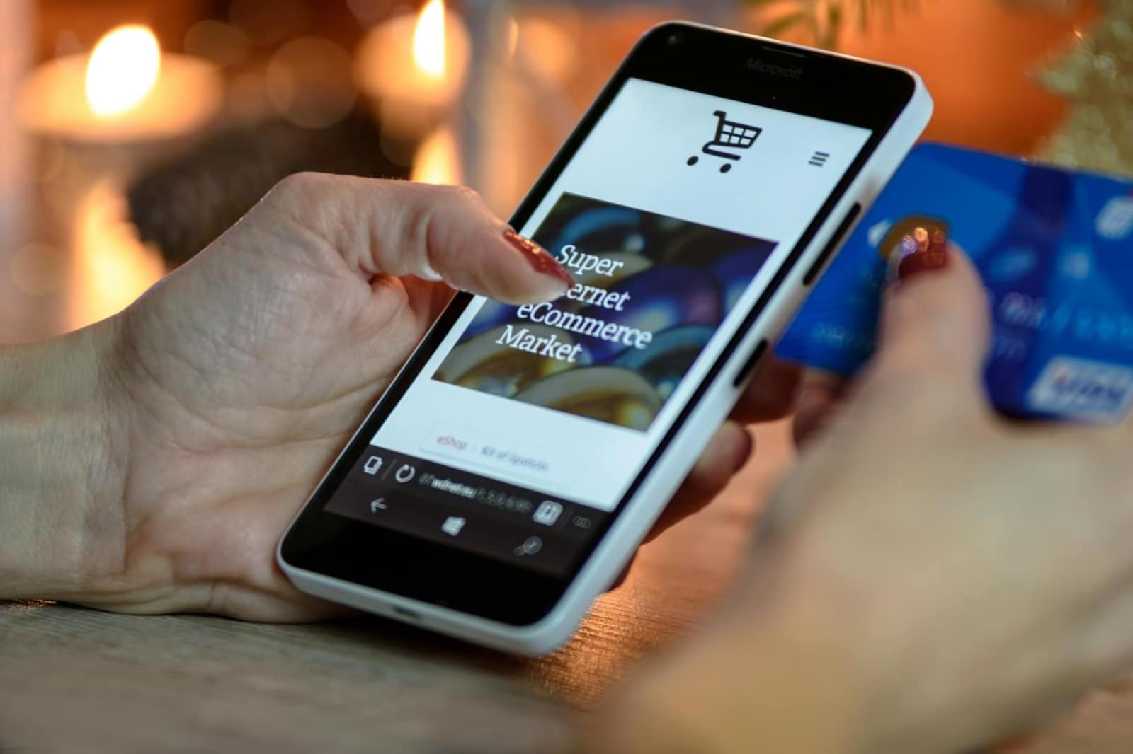 person using black and white smartphone and holding blue card, cargadores móviles